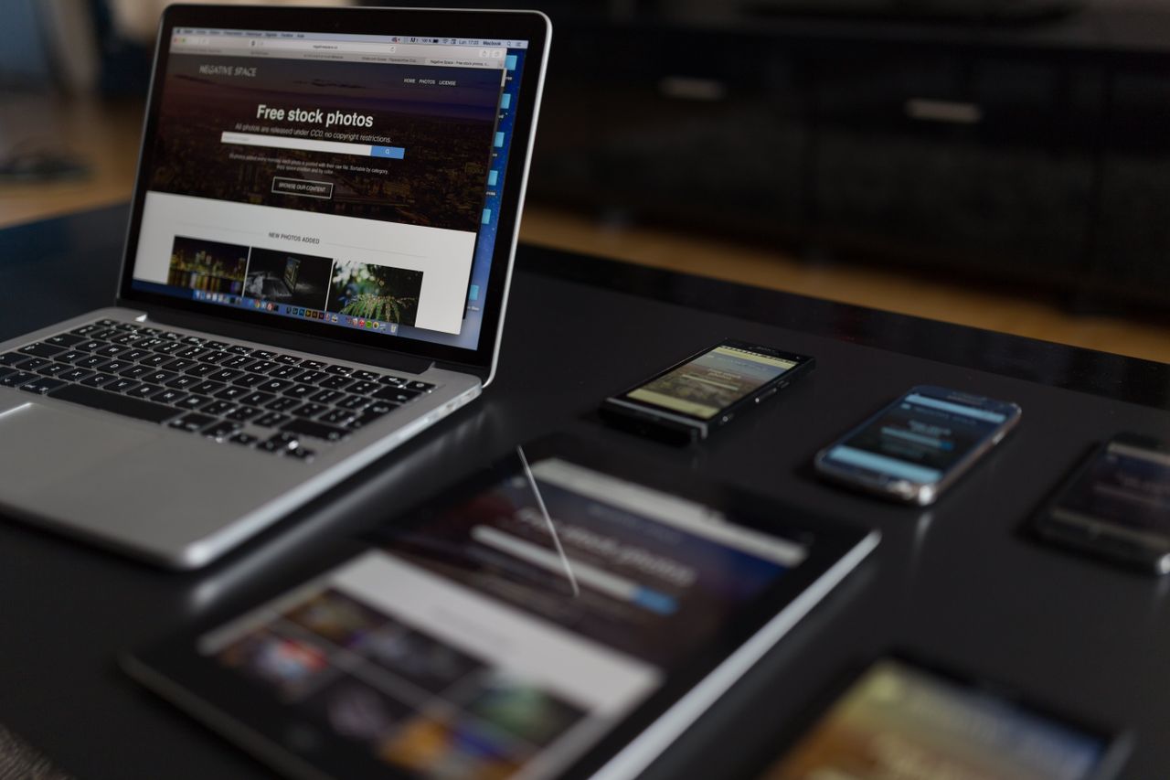 Un espace de travail contemporain mettant en scène un ordinateur portable, une tablette et des smartphones, idéal pour les usages tech et freelance.
